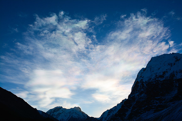 Iridescent clouds above Tent Peak, Nepal Peak and Wedge Peak, as seen from Lhonak